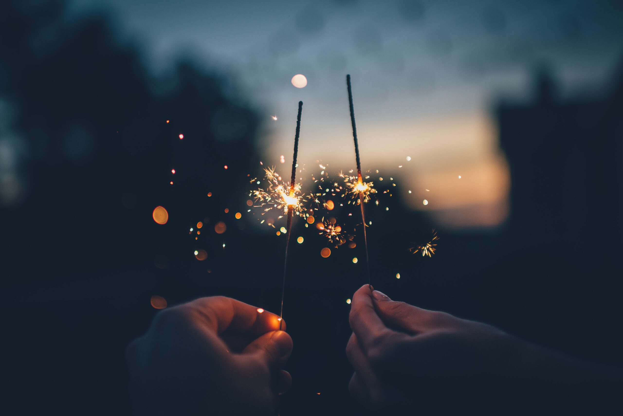 Two hands holding sparklers celebrating their new years resolutions from our divorce solicitors