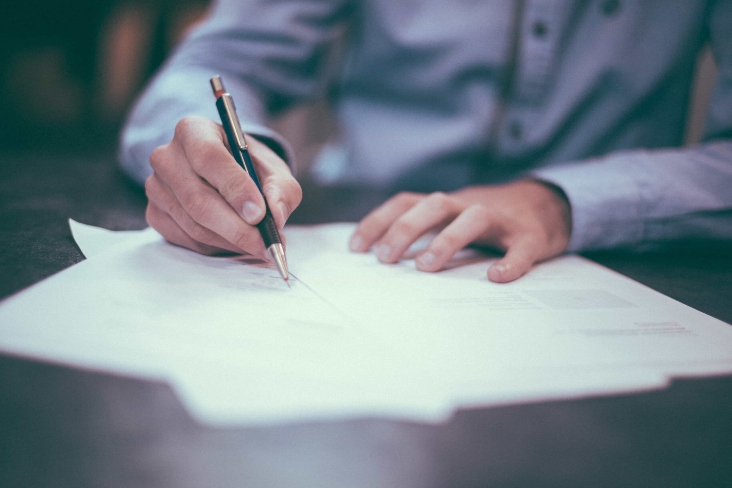 Close up of hand writing on paperwork at a family lawyer firm in London