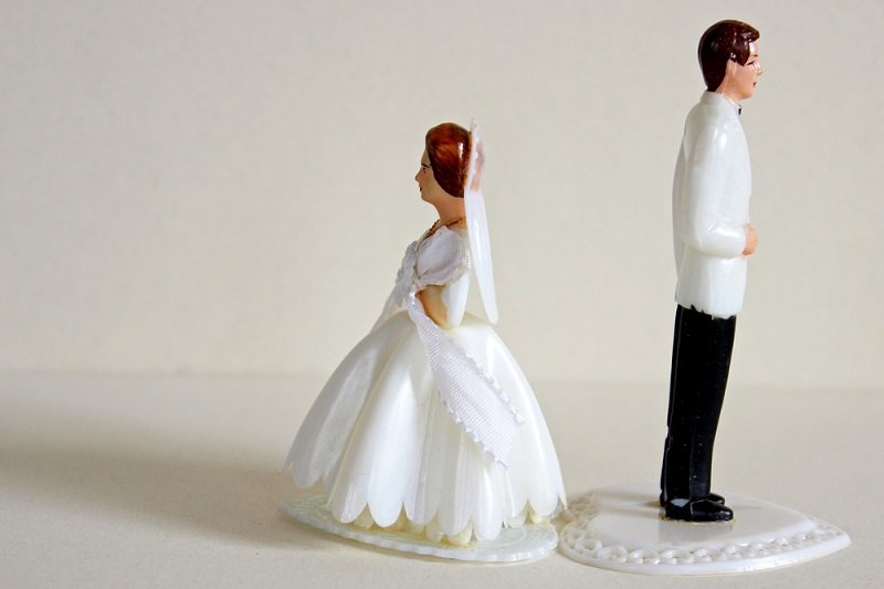 Bride and groom figures standing back to back symbolising breakdown of marriage, annulment and divorce